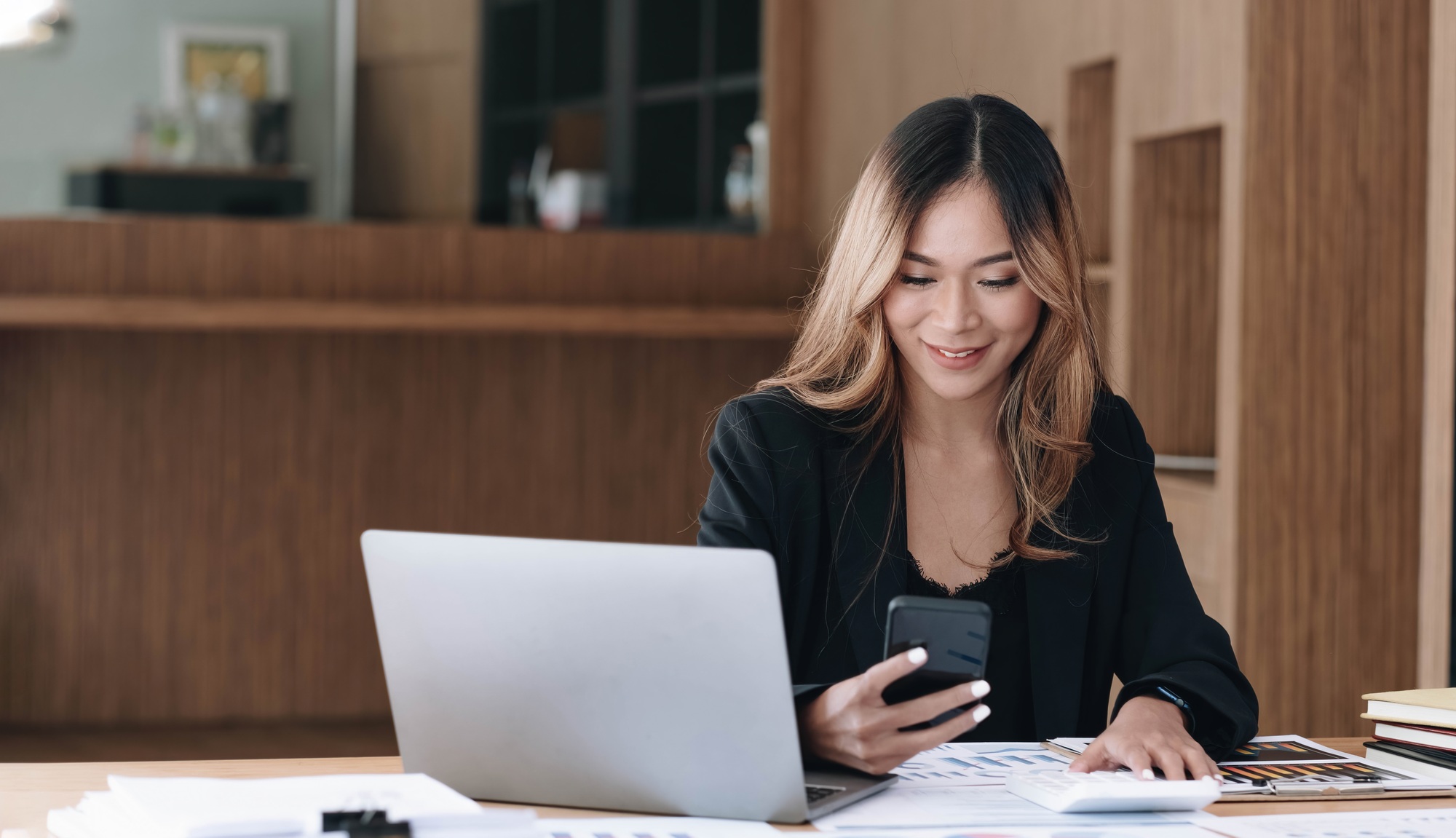 Asian businesswoman relax and enjoy playing mobile phone at office.