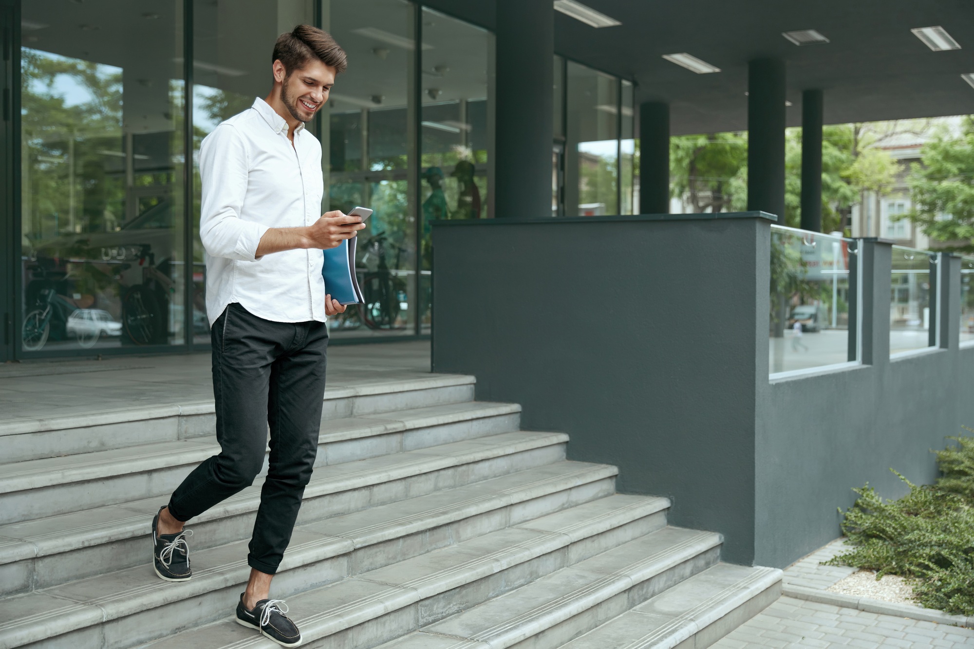 Businessman going on stairs and using mobile phone