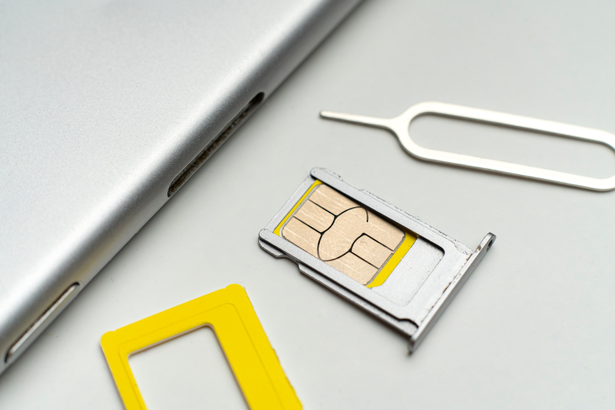 the process of changing the sim card in smartphone flat lay on color surface, macro view